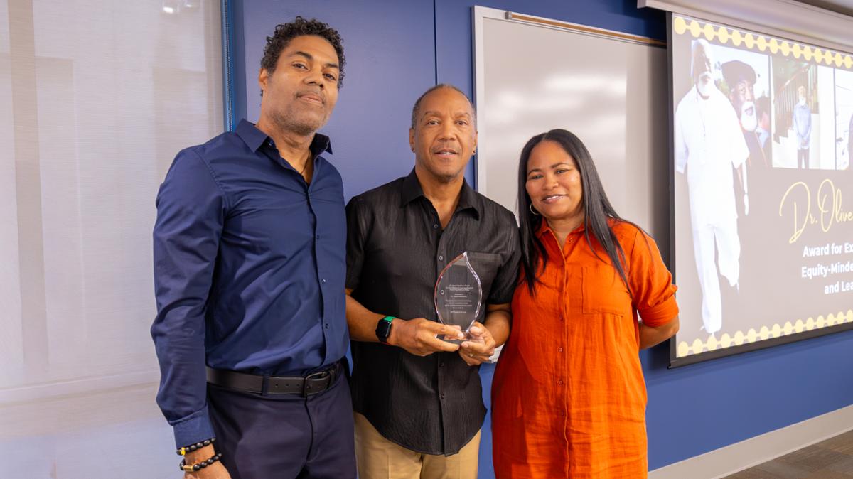 Faculty standing with award