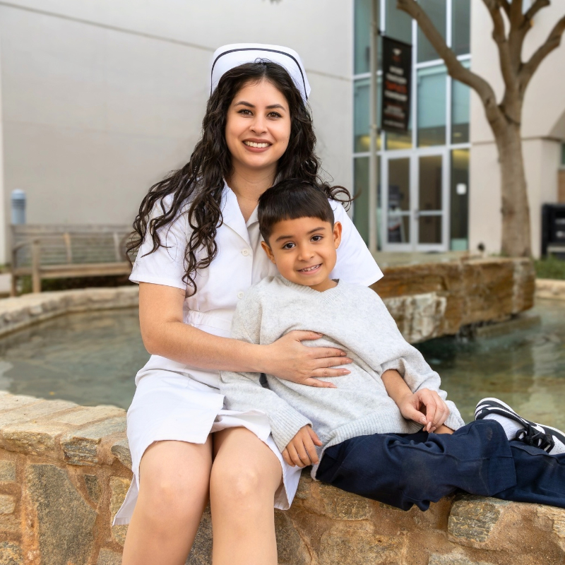 Student in nursing uniform with son
