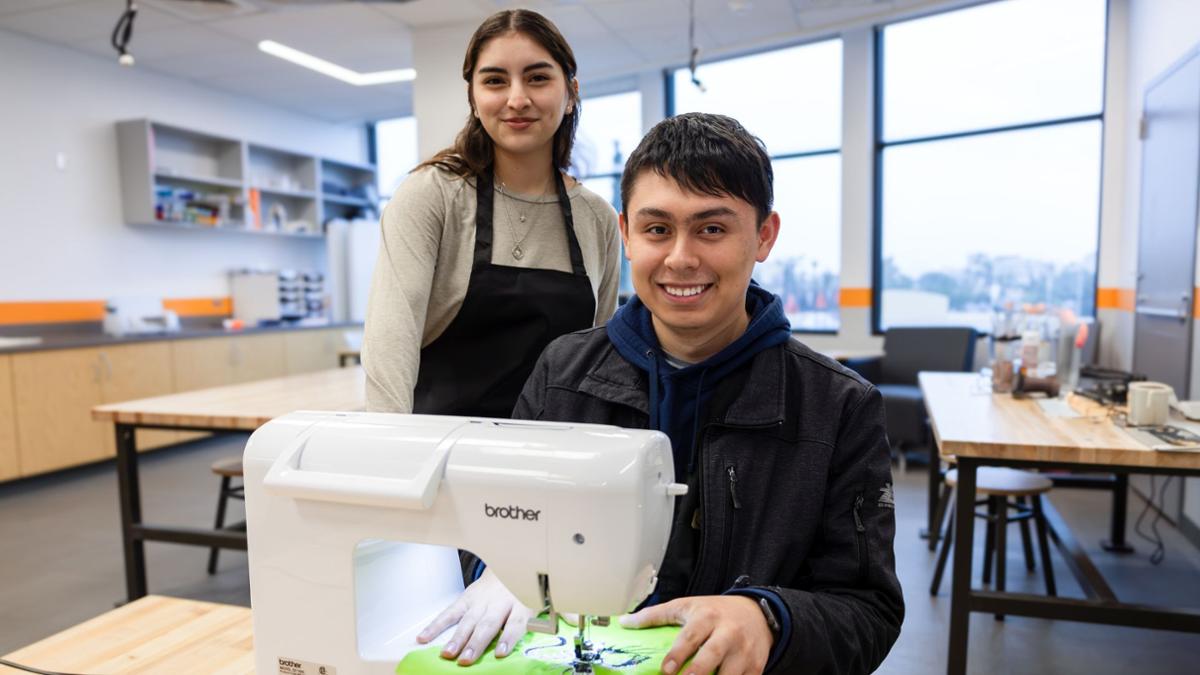Students in the makerspace working on a sewing machine